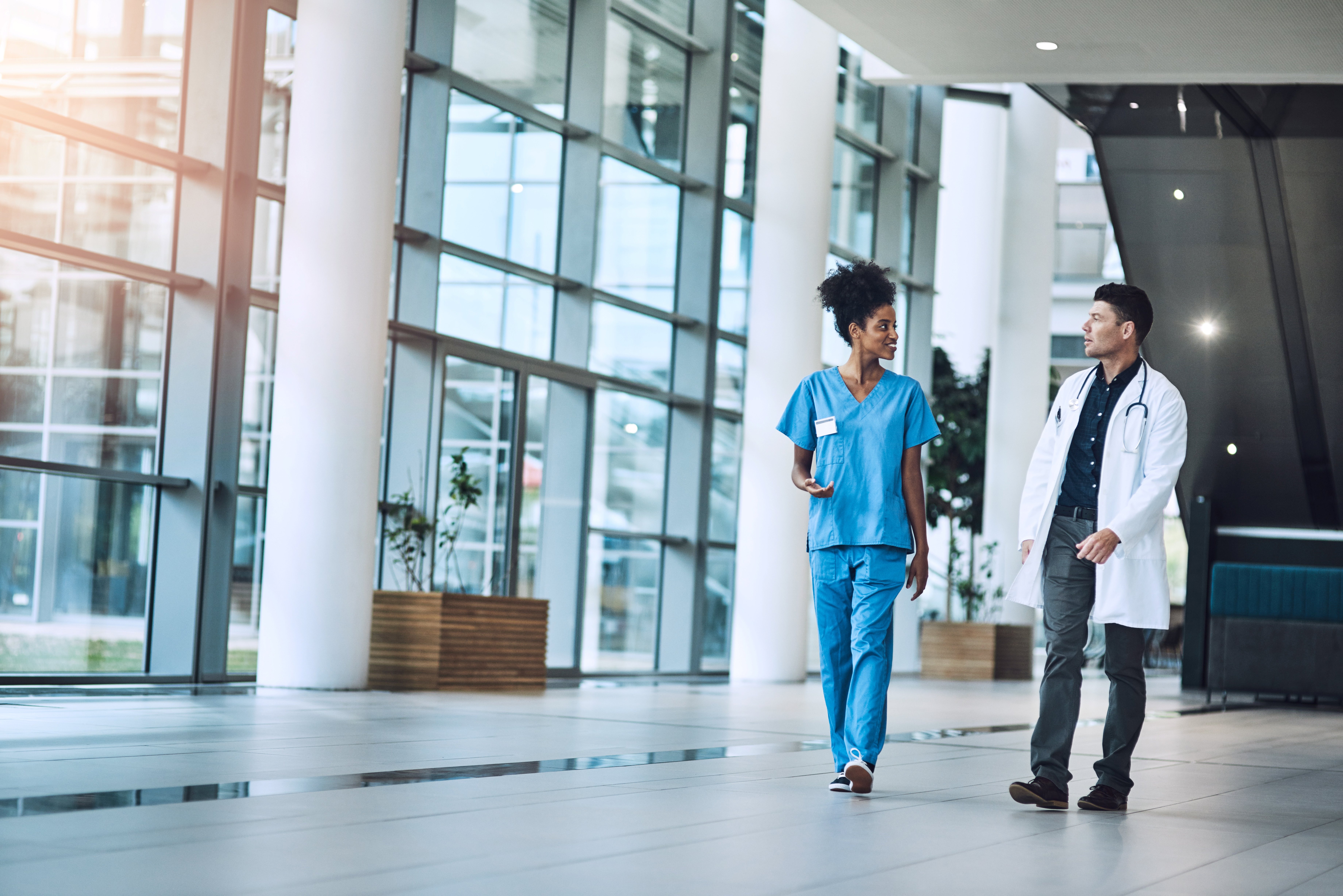 A nurse and physician walking through a hospital